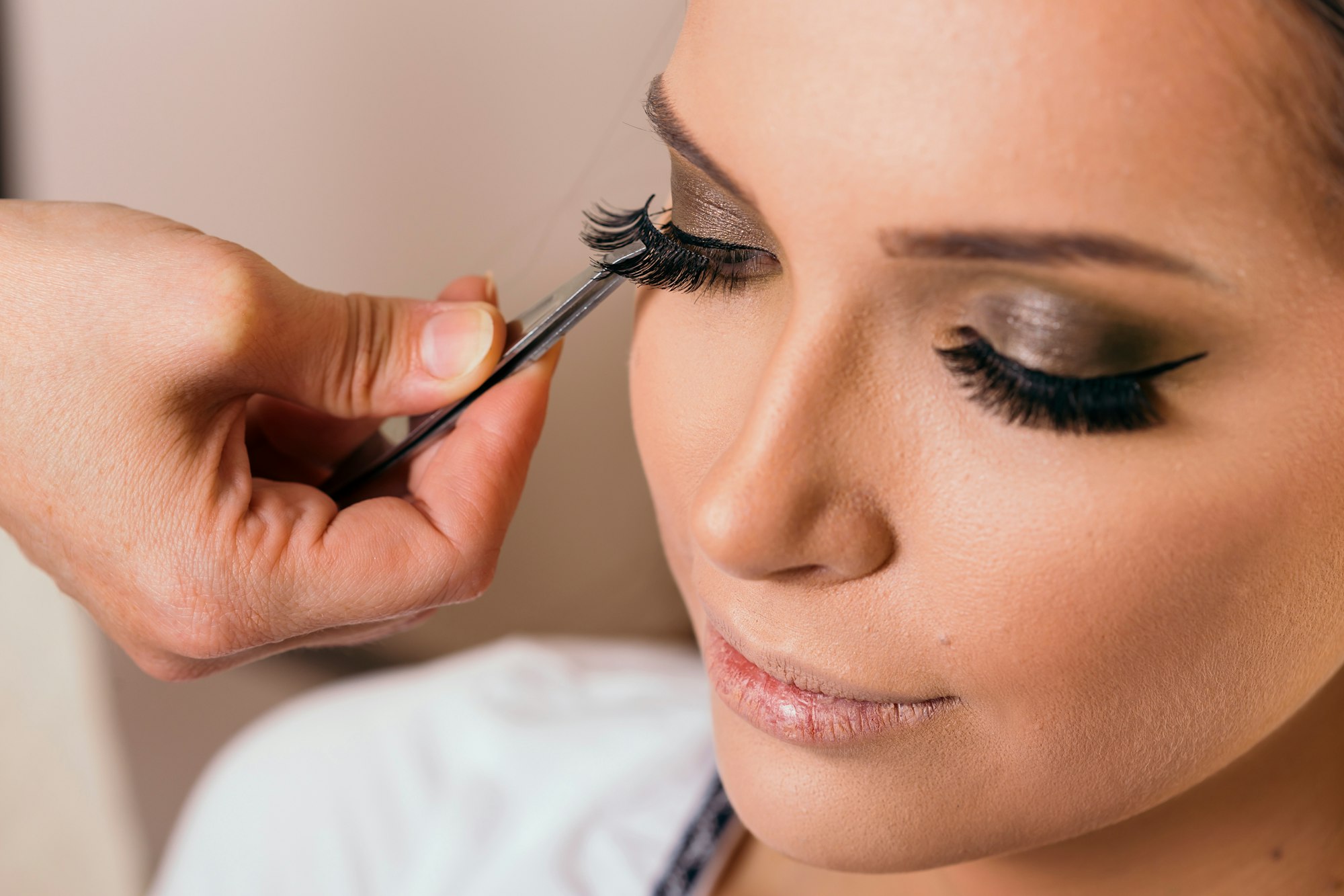 Make up artist placing artificial eyelashes