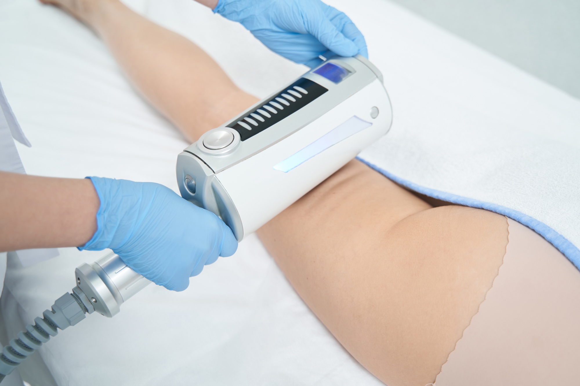 Cosmetologist performing leg body sculpting with endosphere
